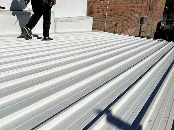 Roof plumber working on a newly sheeted metal roof