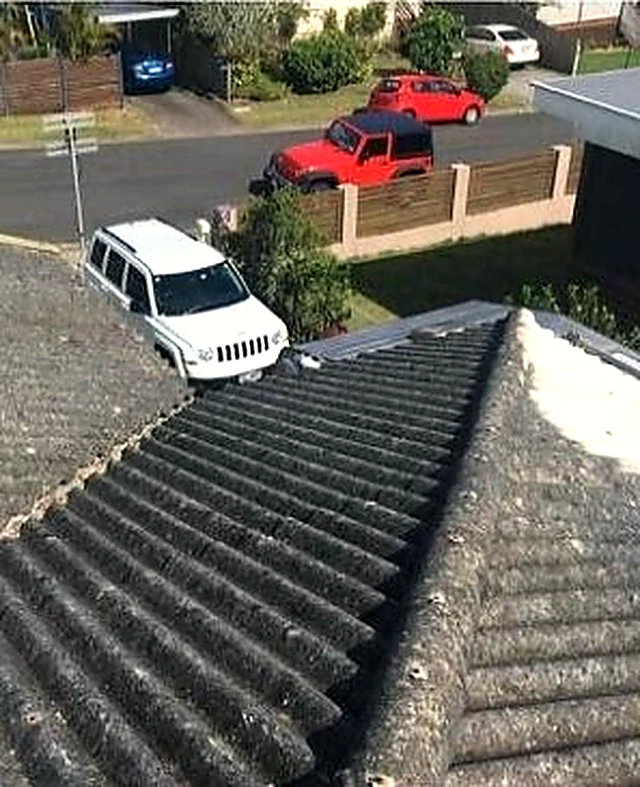 Old corrugated fibro roof with weathered sheets before replacement