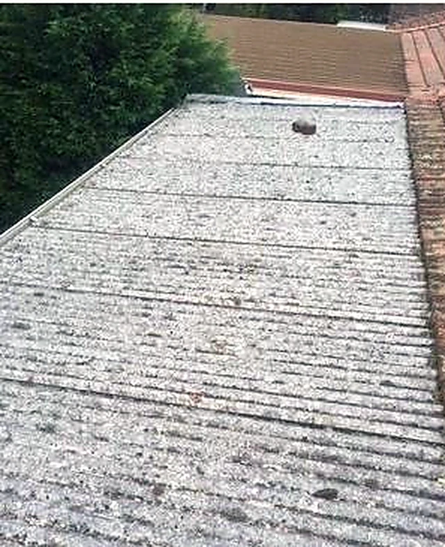 Badly degraded roof sheeting covered in lichen before restoration